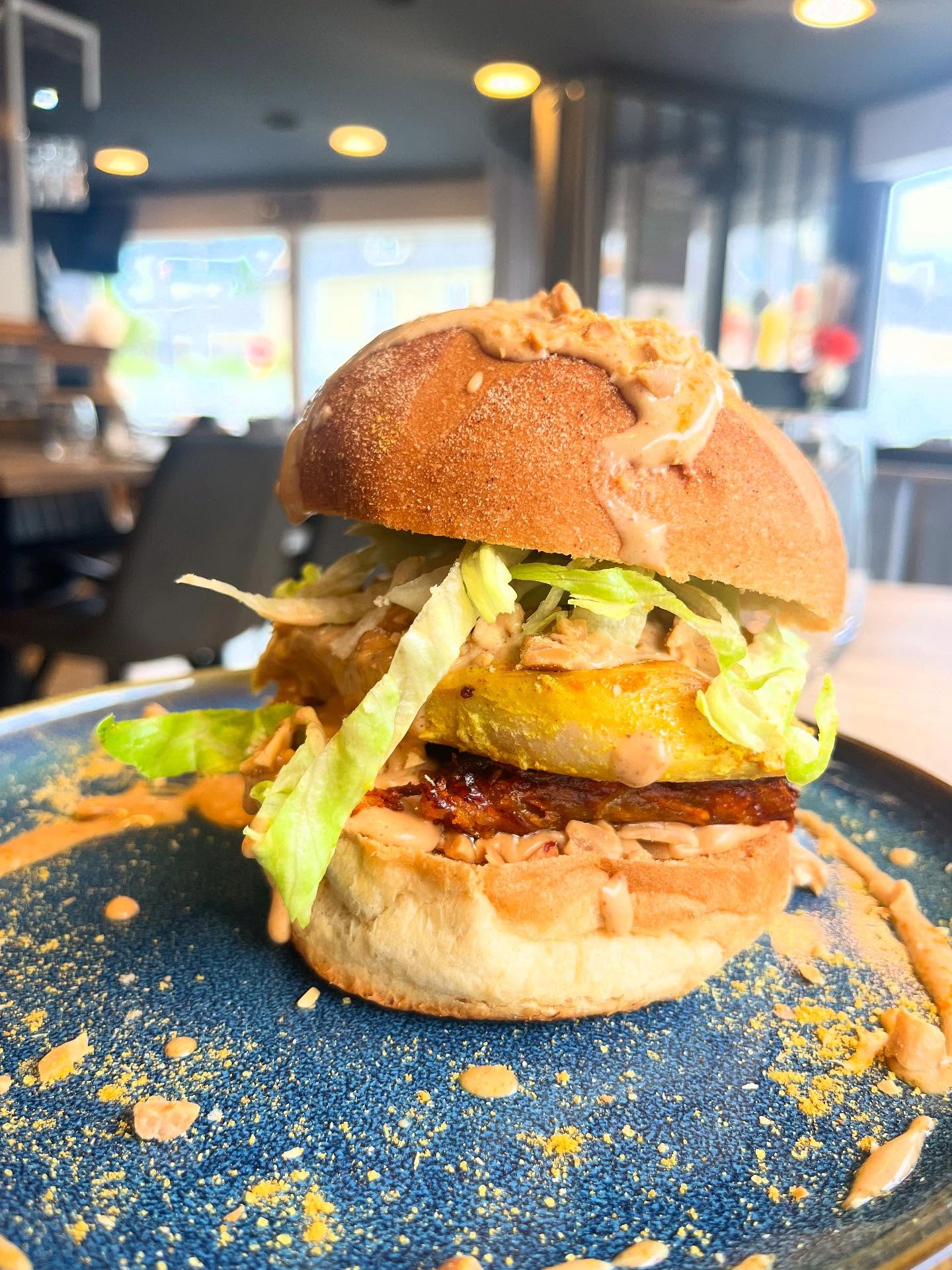 Burger du 19 dressé sur assiette bleue.